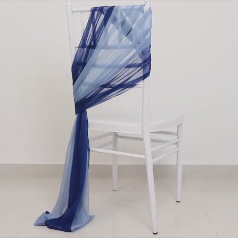 Navy blue and dusty blue sheer chair sash draped on a white chair.