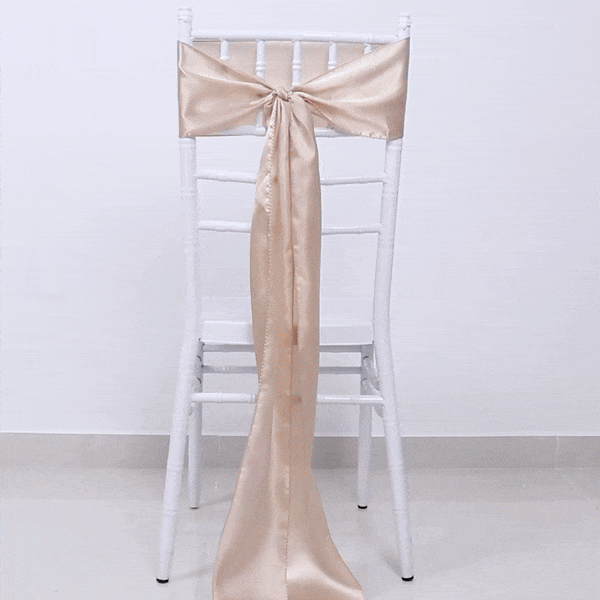 Black 3D rose-shaped chair sash pin buckle with gold rim on a white chair.