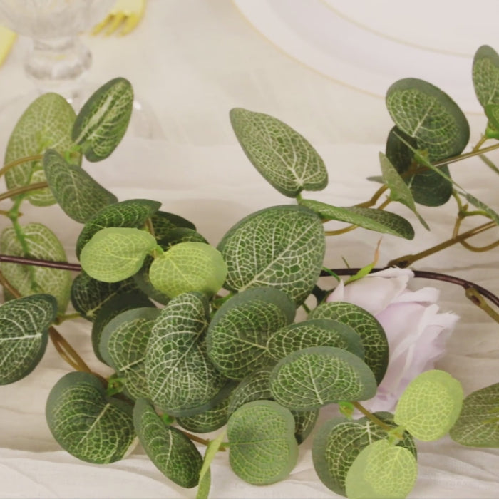Artificial eucalyptus garland with cream silk roses and green foliage.
