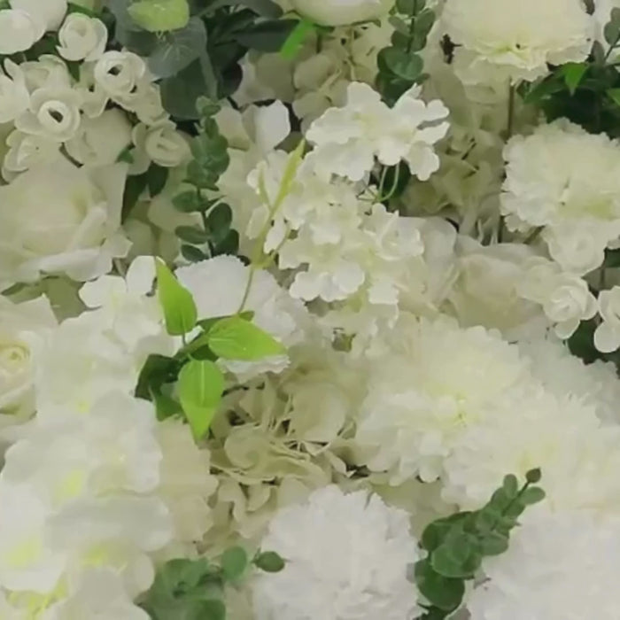 White artificial floral centerpiece with roses, hydrangeas, and chrysanthemums.