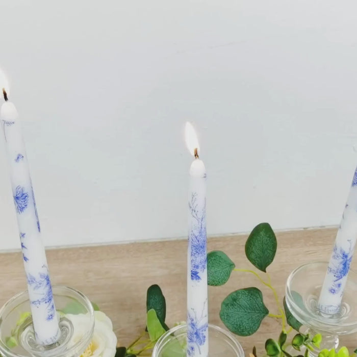 White and blue French toile wax taper candles in elegant candle holders.