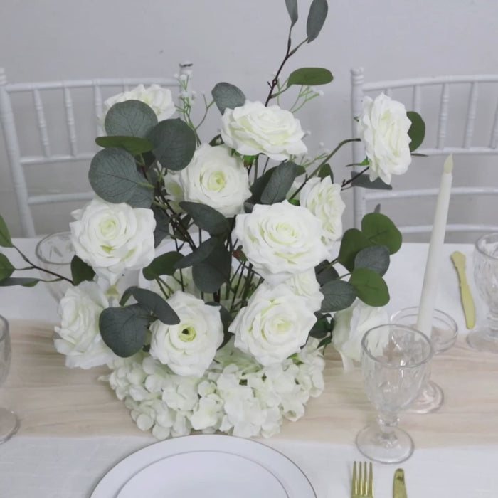 White artificial flower arrangement with roses, hydrangeas, and eucalyptus.