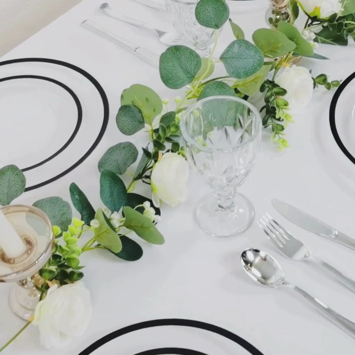 Clear charger plates with wide black rim on a dinner table setting.