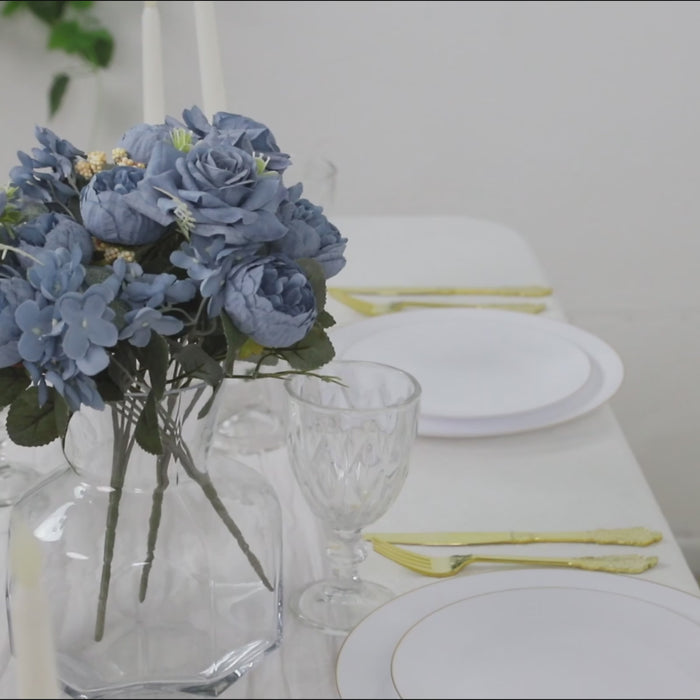 Dusty blue silk rose bouquet with peonies and hydrangeas in a glass vase.