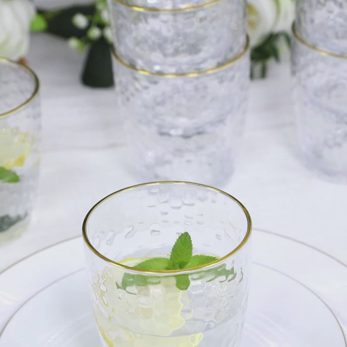 Clear shatterproof tumblers with gold rim for cocktails.