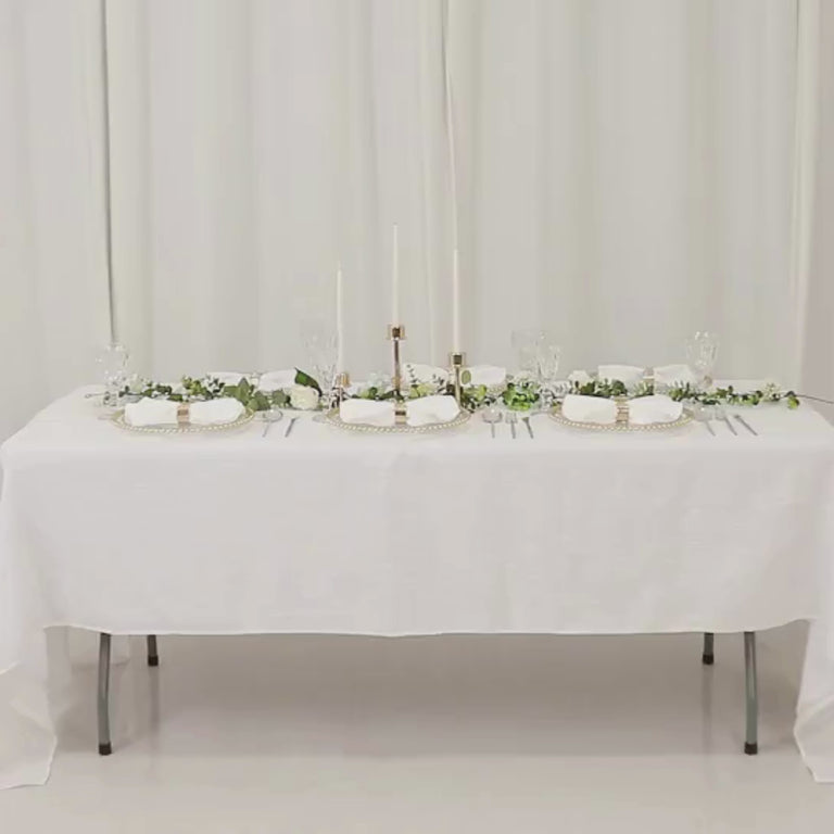 Clear acrylic charger plates with gold beaded rim on a decorated dinner table.