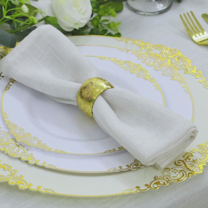 Ivory charger plate with gold embossed baroque rim, elegant dinner setting.