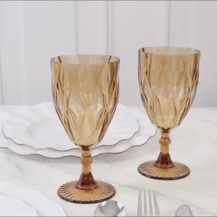 Amber gold vintage plastic wine goblets on a marble table.