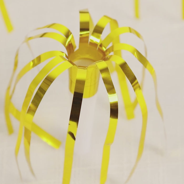Gold metallic party horn noisemaker with fringed tassels.
