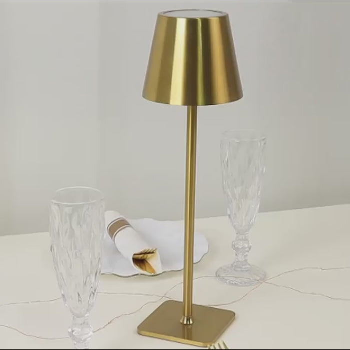Gold metal LED table lamp with classic empire lampshade on a dining table.