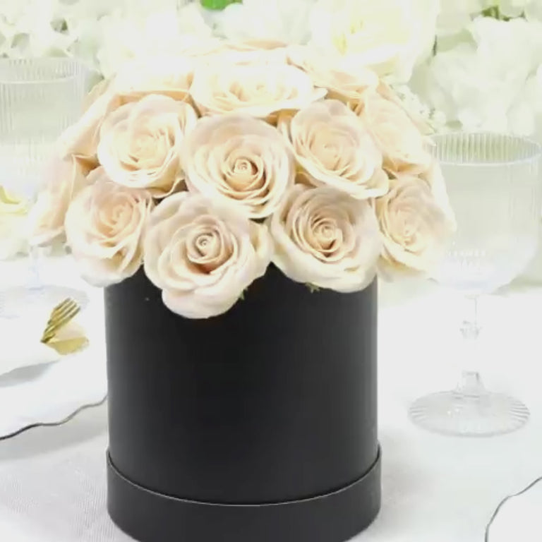 Ivory rose centerpiece arrangement in a black round gift box.