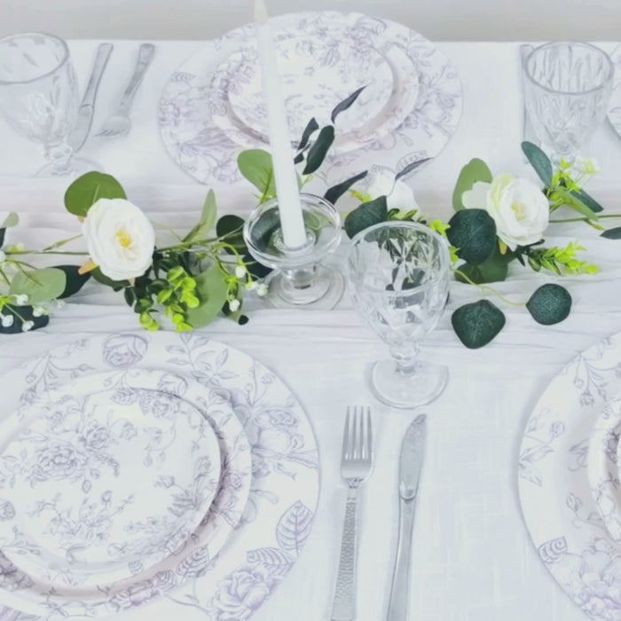 White paper round dinner plates with lavender lilac floral pattern on a table setting.