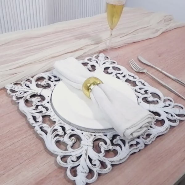 Antique white acrylic charger plate with hollow lace border on a table setting.