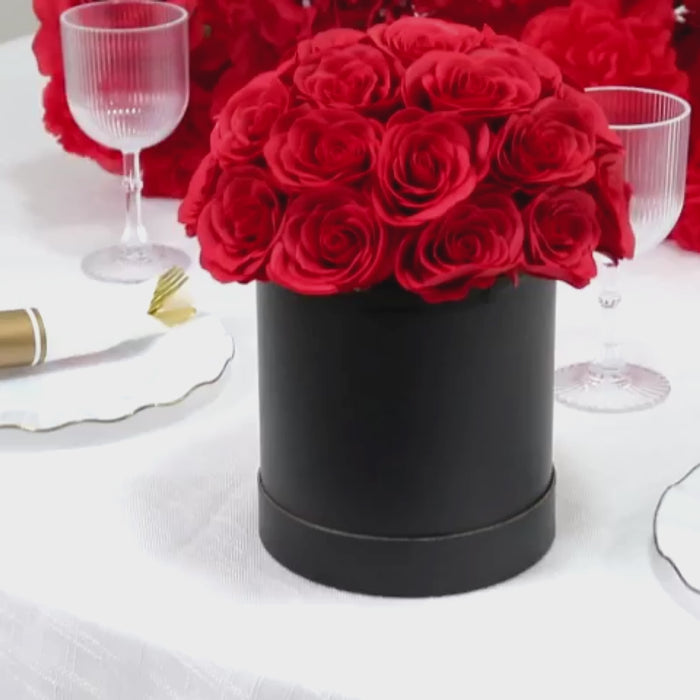 Red rose centerpiece arrangement in a black round gift box.