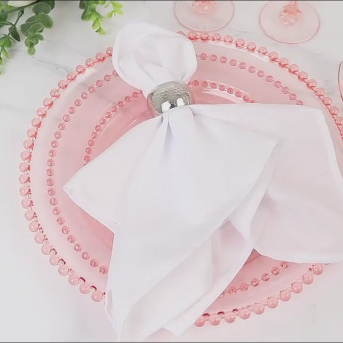 Transparent blush charger plate with beaded rim for decorative dining.