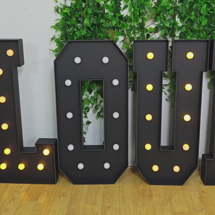 Black LED marquee letter "E" with warm white lights.