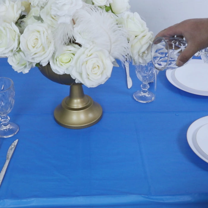 Royal blue table cover with a floral centerpiece and glassware.