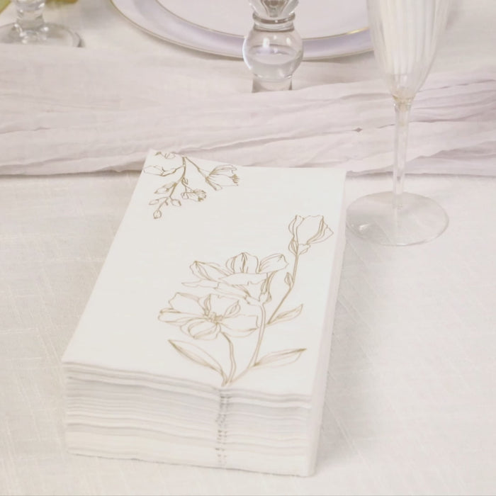 White 2-ply paper dinner napkins with gold lily flowers print.