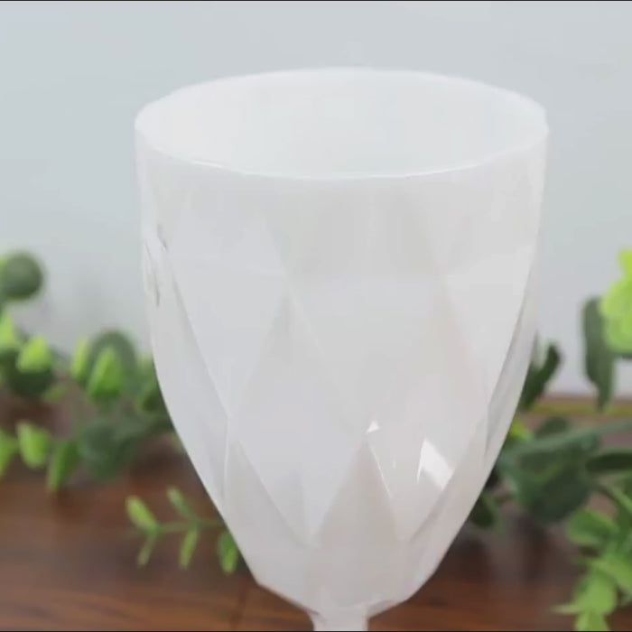 Pearl white diamond cut vintage plastic wine goblet on a wooden surface.