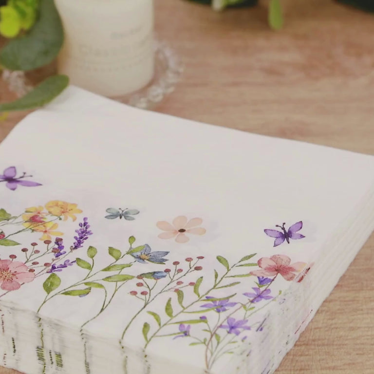 Wildflower butterfly design paper cocktail napkins in soft pastel colors.