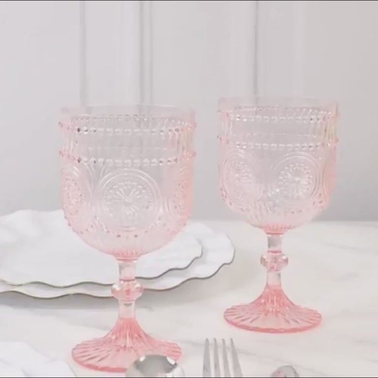 Blush vintage plastic wine goblets with embossed floral pattern.