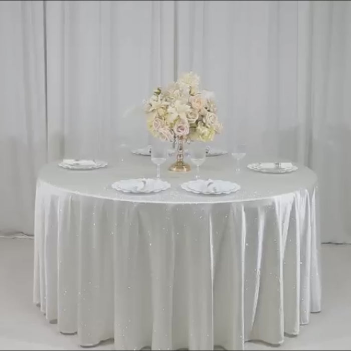 Pearl white tablecloth with rhinestone accents on a dining table.