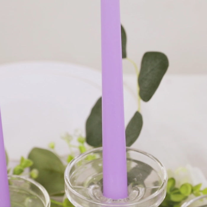 Lavender taper candles in a glass holder, perfect for elegant decor.