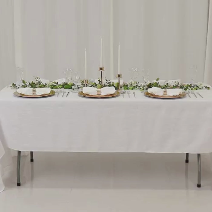 Metallic gold beaded rim charger plates on a white table setting.