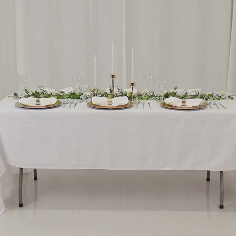 Metallic gold beaded rim charger plates on a white table setting.