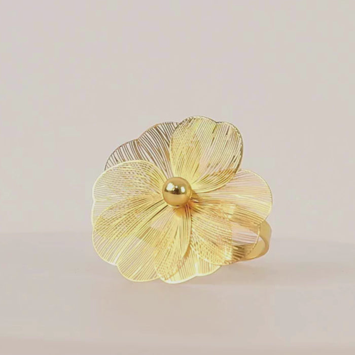 Gold metal jasmine flower napkin ring with pearl center.