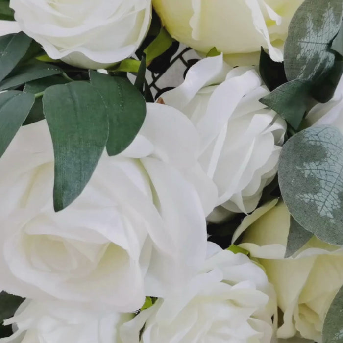 White silk rose floral swag with eucalyptus leaves for wedding decor.