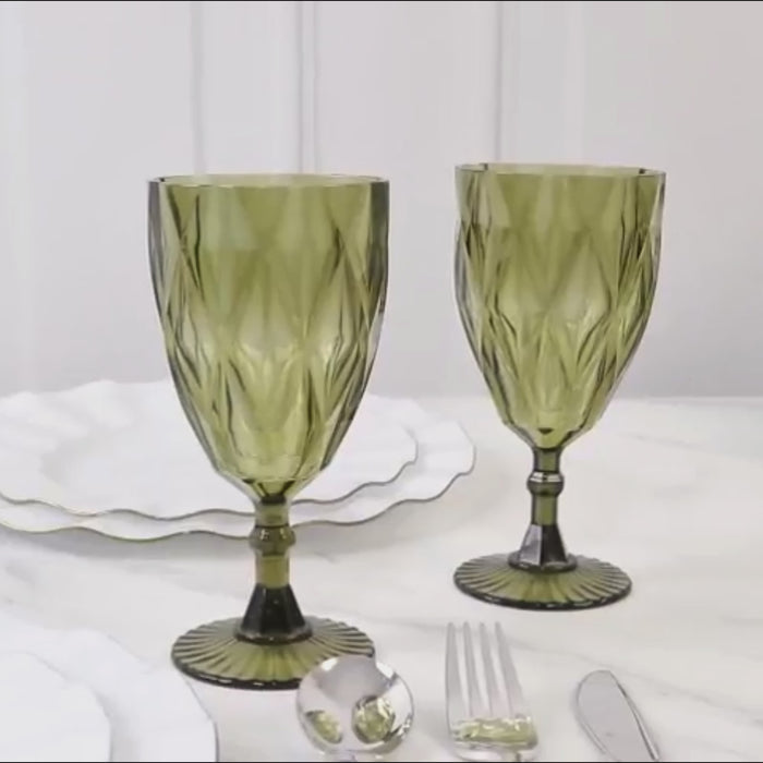 Dusty sage green vintage plastic wine goblets on a marble table.