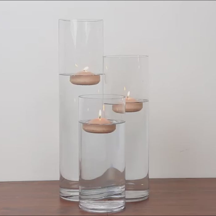 Beige floating candles in water for elegant centerpieces.