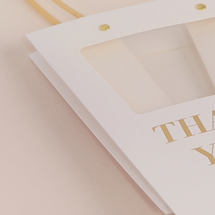 Clear window white paper gift bag with handles in trapezium shape.