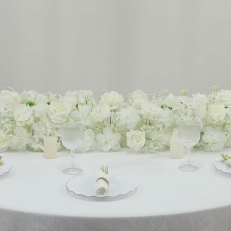 White floral runner with roses, hydrangeas, and baby's breath for wedding decor.