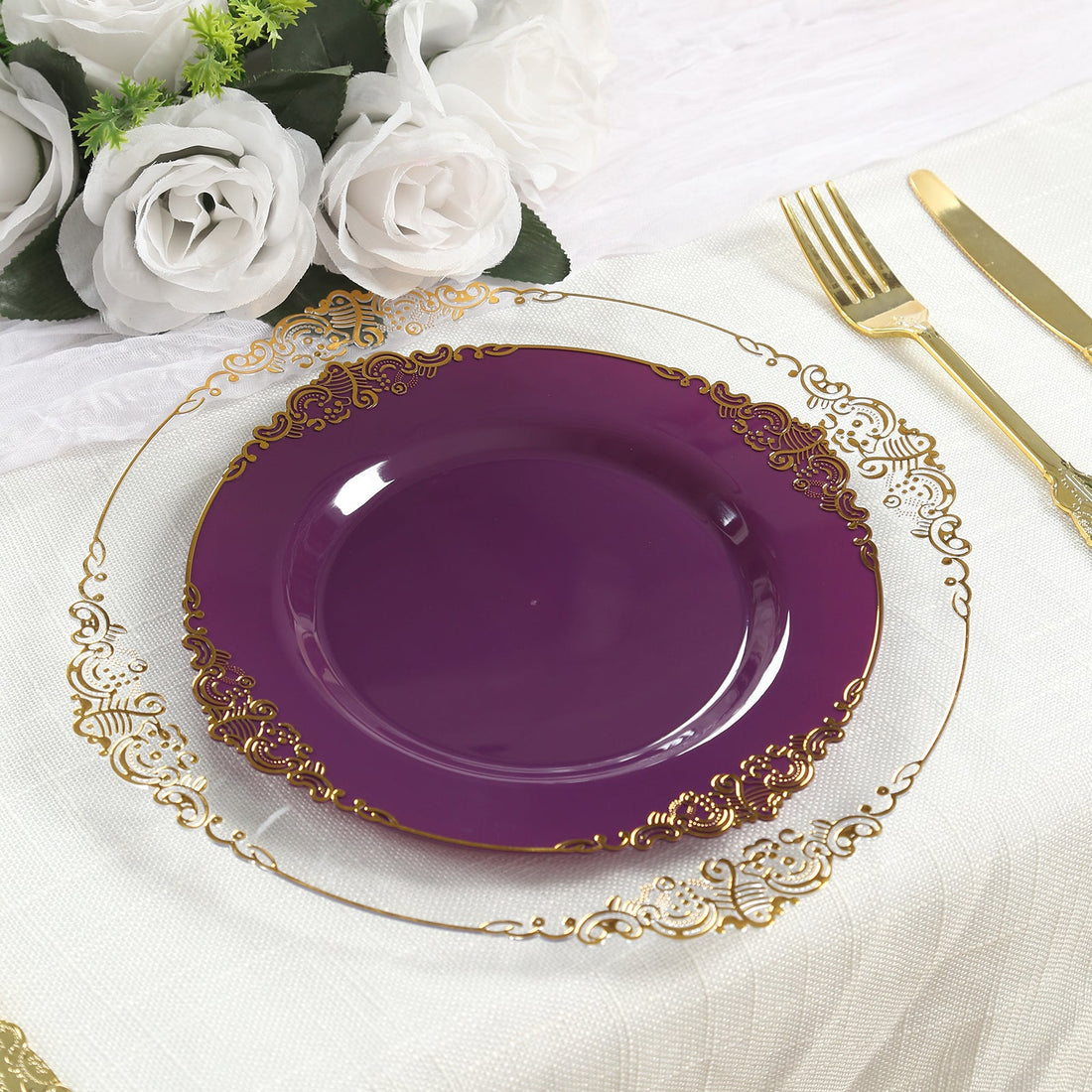 Purple decorative plate with gold accents on a dining table setting.
