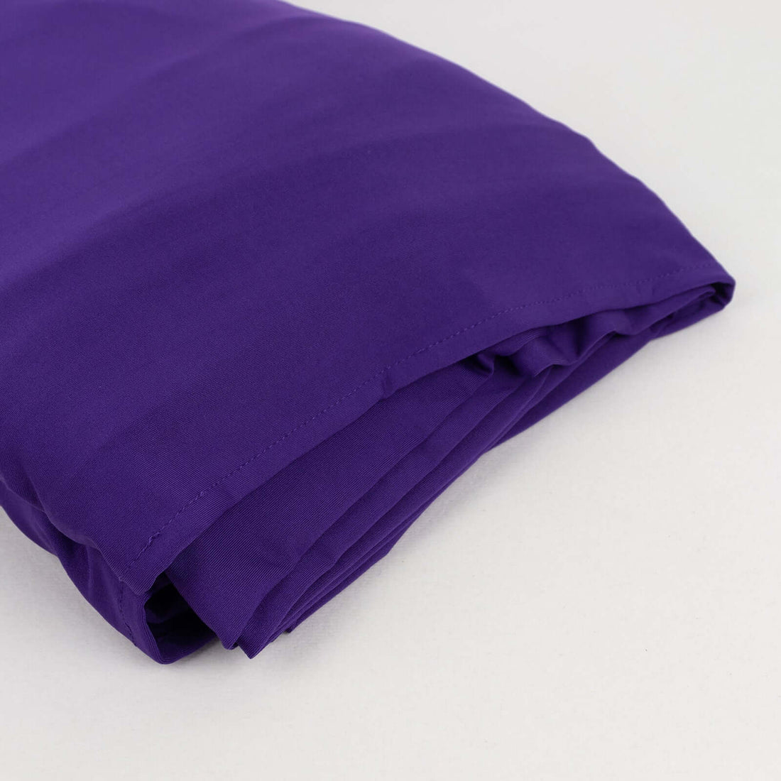 Purple fabric folded neatly on a plain background.