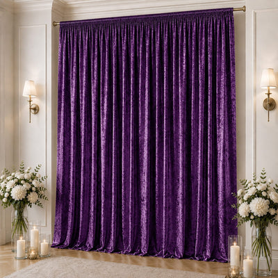 Purple velvet curtains in elegant living room with candles and floral arrangements