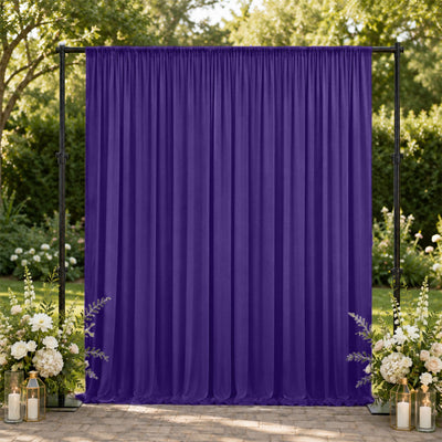 Purple wedding backdrop curtain with floral arrangements and lanterns outdoors