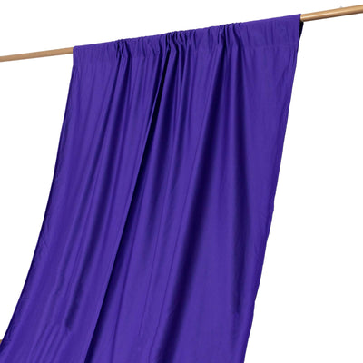 Purple fabric draped on a wooden rod against a white background