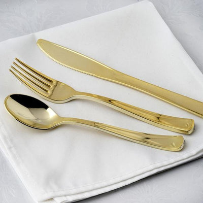 Gold cutlery set on white napkin.