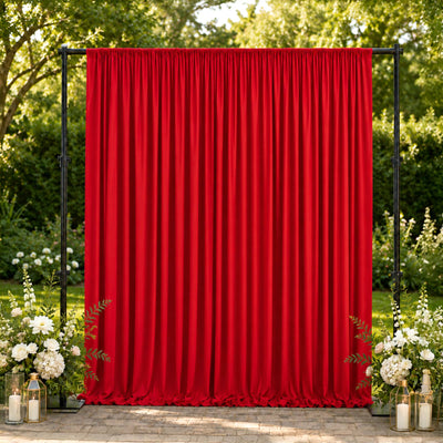 Red outdoor wedding backdrop curtain with floral arrangements and candles