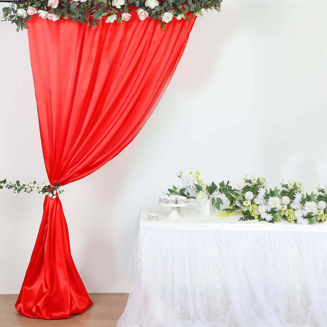 Red draped fabric backdrop with floral accents and a white table arrangement #whtbkgd