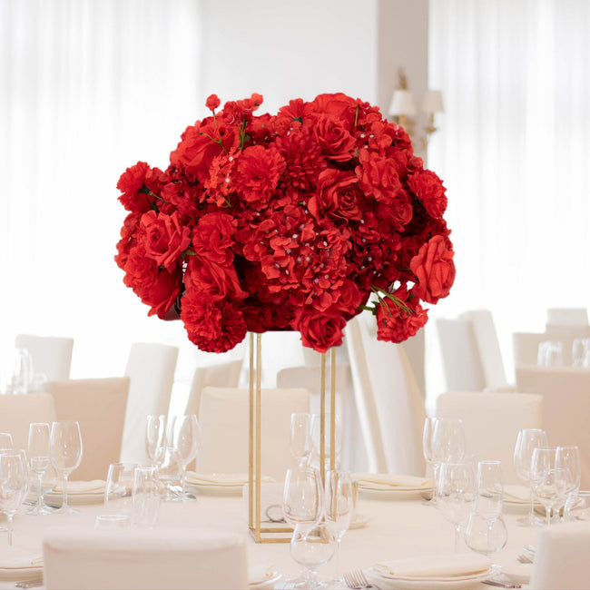 Red floral centerpiece arrangement in an elegant dining setting.