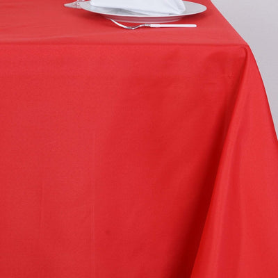 Red tablecloth draped elegantly over a table with a white plate.