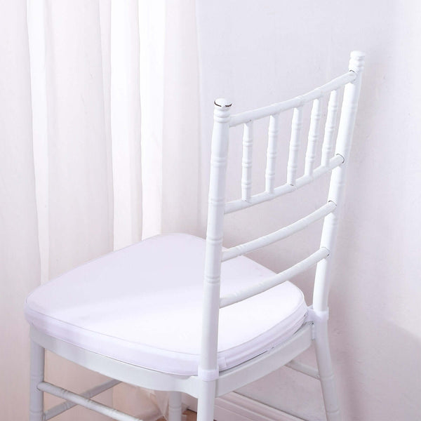 White chiavari chair with cushion against a plain backdrop.
