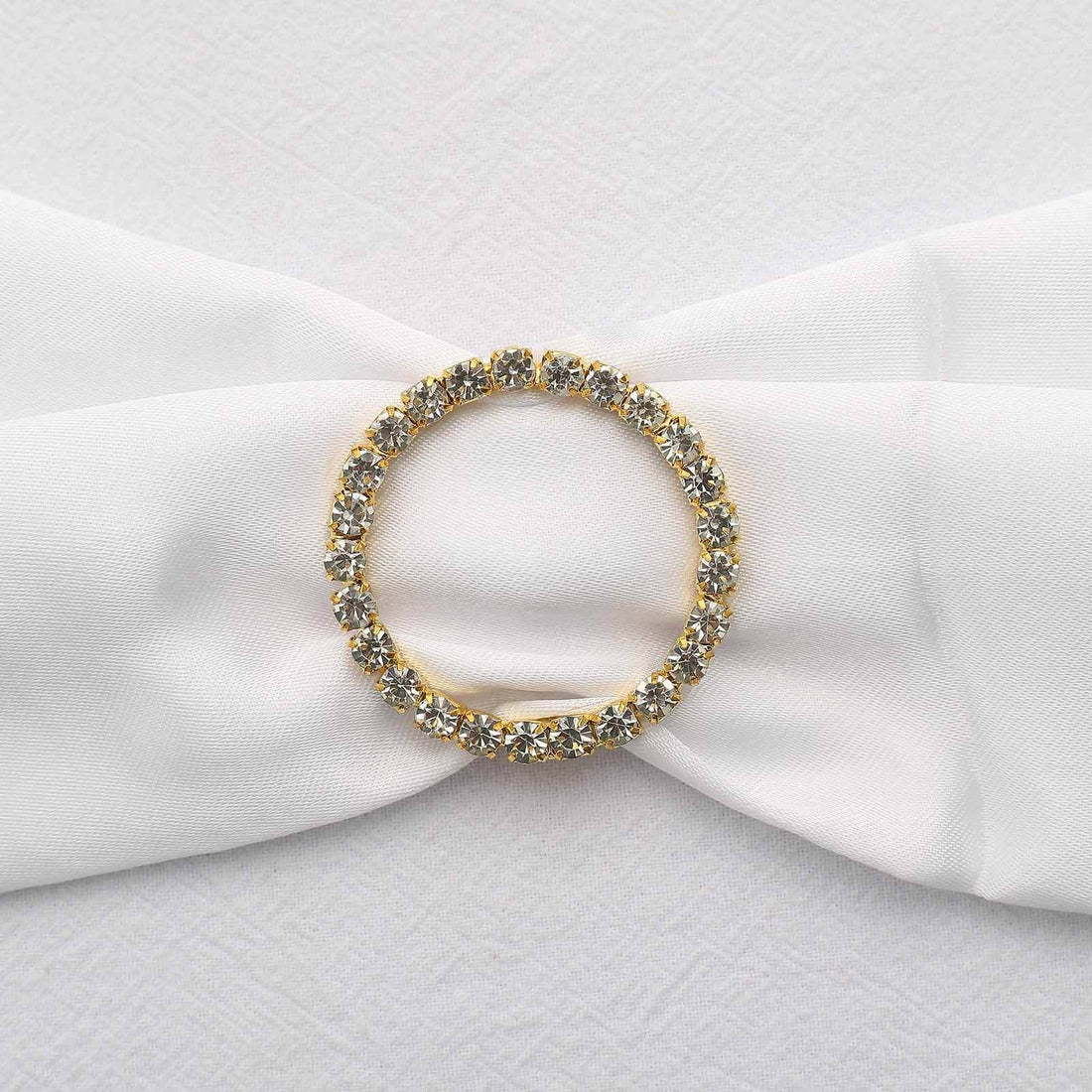 Gold and crystal embellishment on white fabric bow