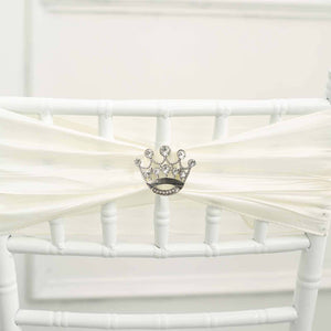 Silver crown decor on white chair sash for elegant events.