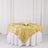 Gold rose tablecloth draped over a round table with white skirt.