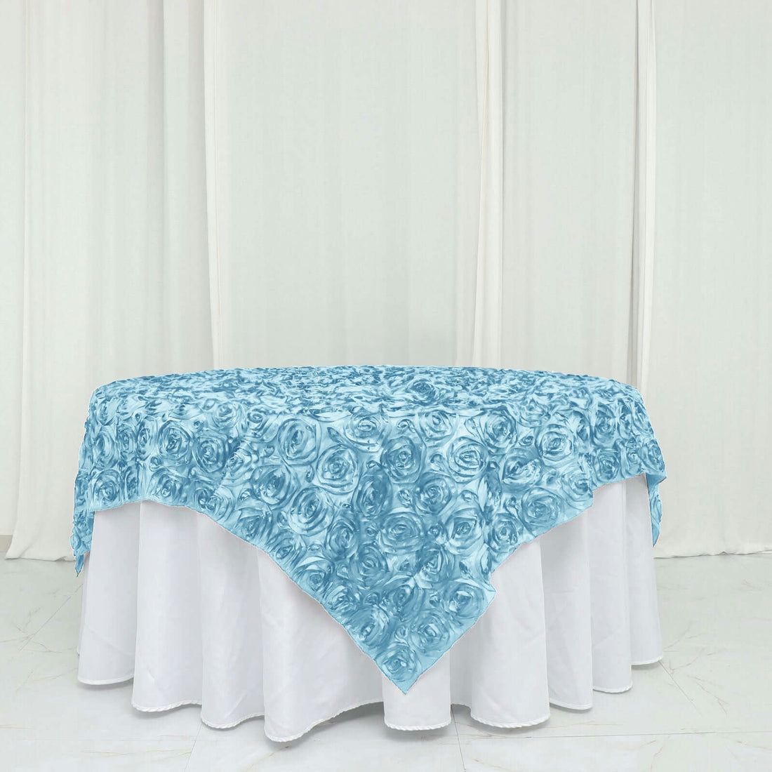 Light blue rose-patterned tablecloth draped on a white table.